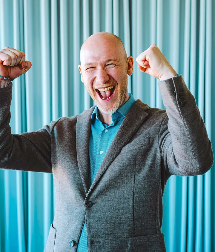 Marian Kamenistak laughing with both fists raised in celebration.