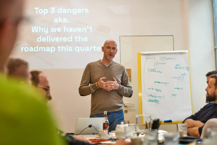 Marian Kamenistak in a leadership workshop, in front of a slide titled "Top 3 dangers — Why we haven't delivered the roadmap this quarter."